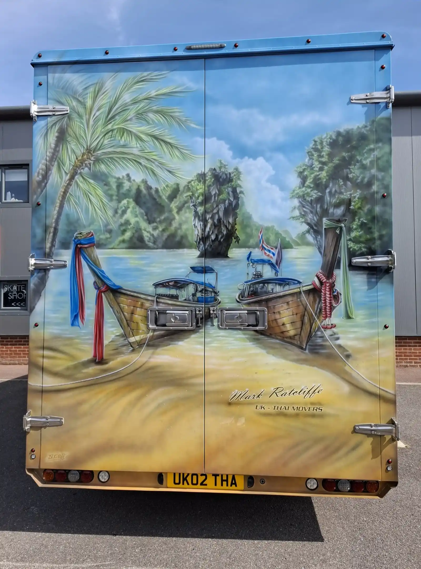 Hand-painted Thailand longtail-boat mural on the rear doors of a Mark Ratcliffe lorry